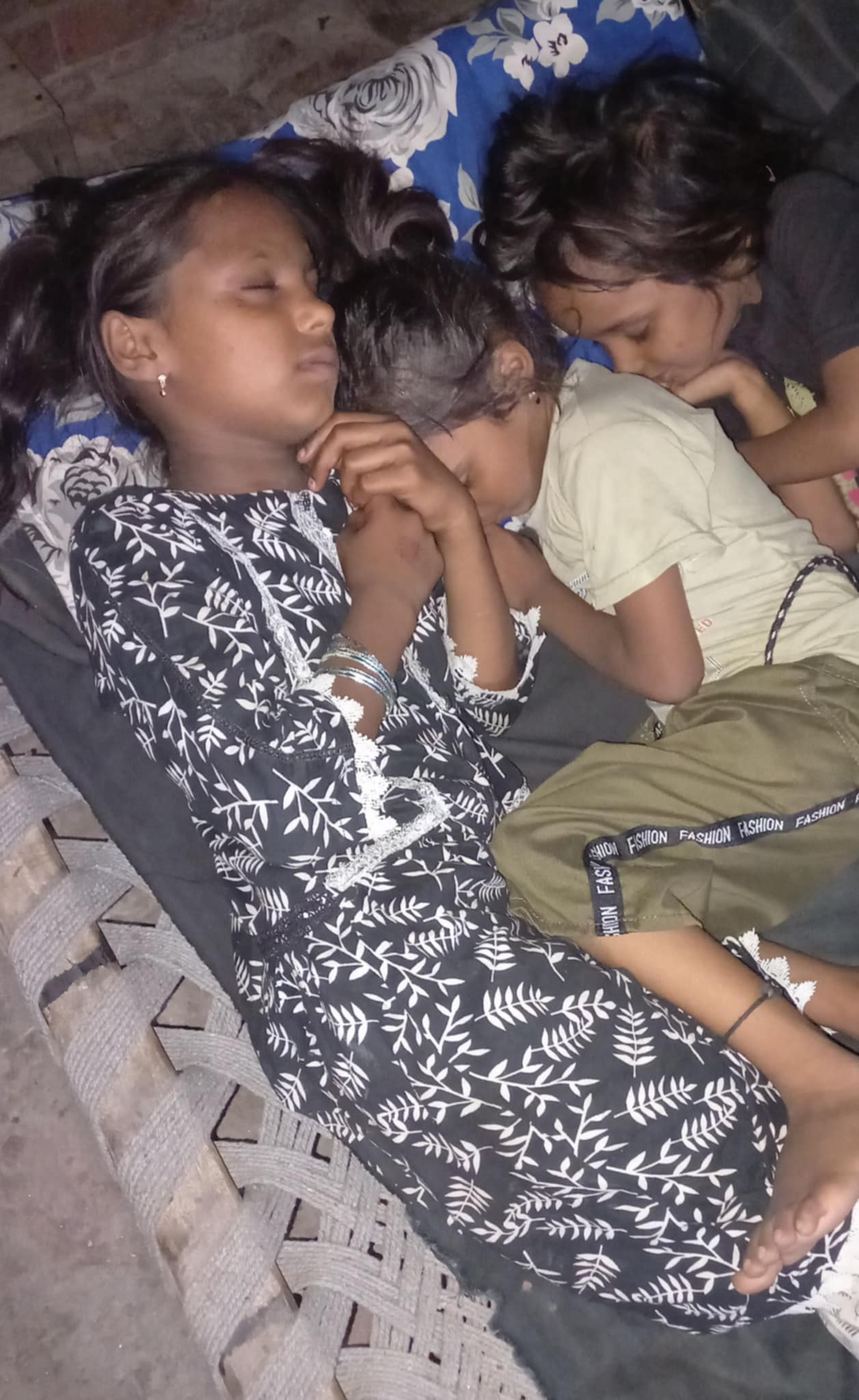 Trois fillettes dorment serrées dans un seul petit lit